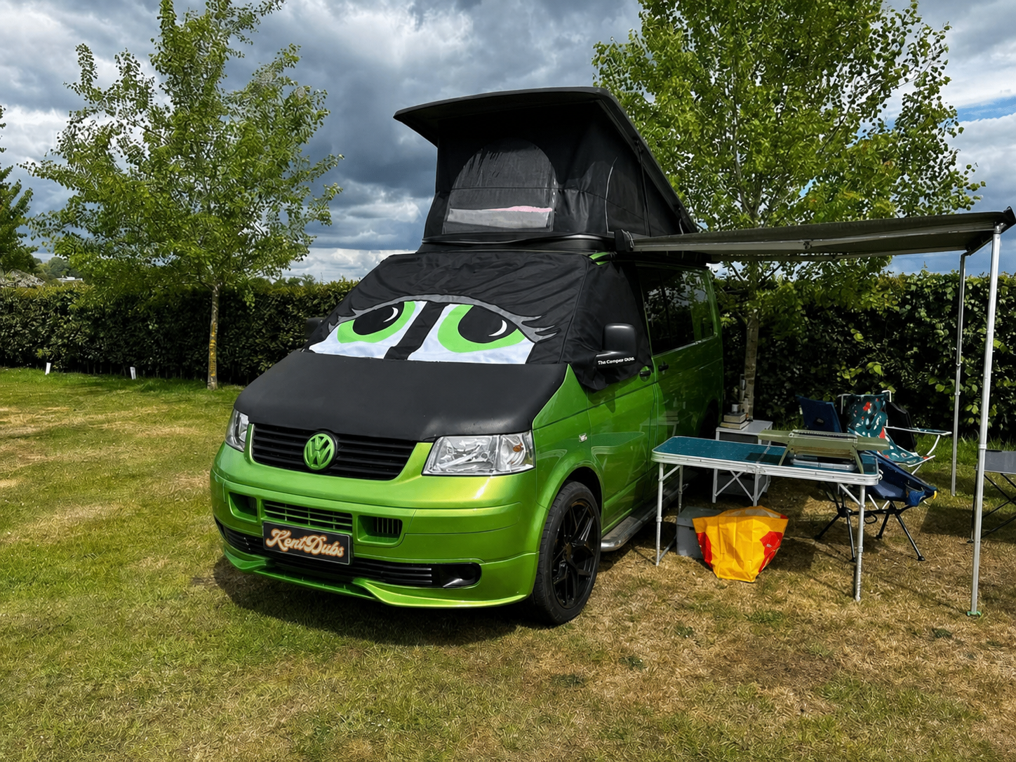 Green Volkswagen camper at an outdoor event with a Kent Dubs windscreen cover
